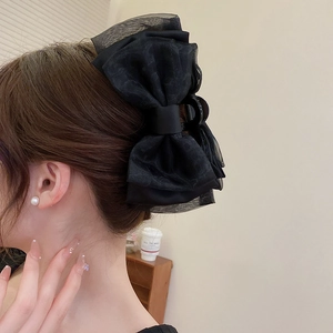 Détail d'une grande pince à cheveux avec nœud en organza noir pour un style élégant et chic