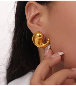 Close-up of elegant gold teardrop earrings showing smooth polished finish on model
