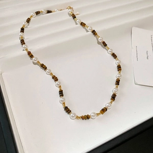 Détail du collier plaqué or 18 carats avec pierres œil de tigre et perles blanches