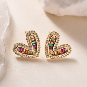 18K gold plated heart stud earrings with sparkling zircon stones on a beige surface