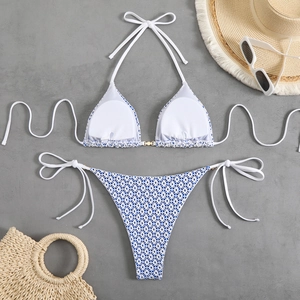 Two-piece floral halter bikini set with side tie bottoms on a beach accessory background