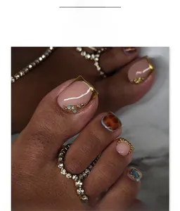 Detailed view of press-on toenails with leopard print and elegant pearl rhinestone accents
