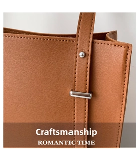 Detail of brown litchi pattern leather tote with stitching and silver metal hardware