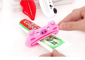 Detail of cartoon animal toothpaste squeezers showing the sliding mechanism in use