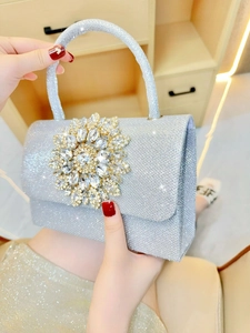 Elegante borsa da sera argento con grande fiore di cristallo portata da una modella