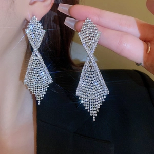 Detail of silver drop earrings with pavé rhinestones and tassel design on model