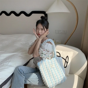 Blue and white striped bubble texture tote bag styled in a cozy minimalist home setting