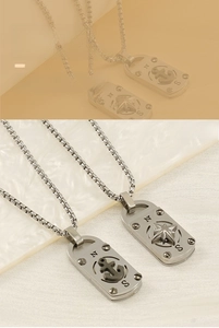 Détail macro d'un pendentif boussole en acier inoxydable avec ancre nautique et gravure N-S