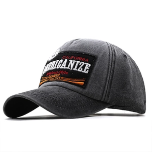 Dettaglio del cappellino in cotone lavato con toppa ricamata vintage e trama invecchiata