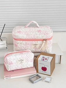 Close-up of pink quilted makeup bags with heart patterns and sweet bow details