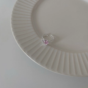 S925 sterling silver open ring with pink heart cubic zirconia on a white ceramic plate