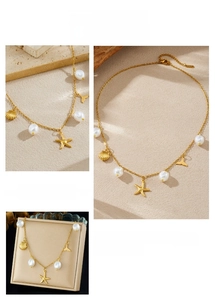Detail of gold stainless steel necklace featuring pearls, starfish, and seashell pendants