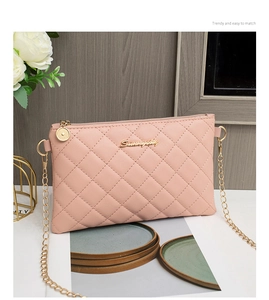 Détail du sac à bandoulière rose matelassé avec chaîne dorée et logo métallique