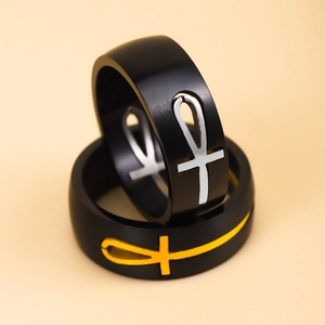 Pair of matte black stainless steel Ankh cross rings with silver and yellow accents