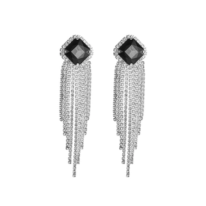 Detailed close-up of luxury black square gem earrings with long sparkling silver tassels