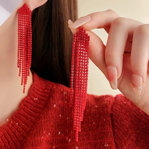 Close-up of elegant red tassel earrings with sparkling rhinestones and silver pins
