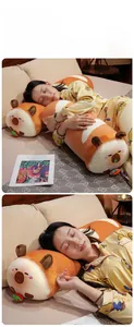 Détail du coussin peluche capybara avec tissu orange doux et broderies de qualité