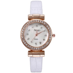 Détail de la montre or rose sertie de strass avec bracelet en cuir blanc gaufré