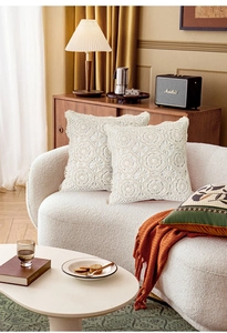 Close-up of handmade crochet pillowcases featuring intricate floral lace textures in beige
