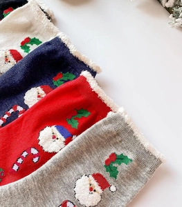 Detail of Christmas socks with Santa Claus embroidery and soft white plush cuffs