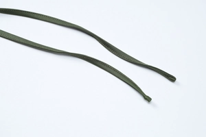 Détail du cordon vert armée avec coutures précises sur un matériau textile de qualité
