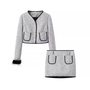 Elegant women's black and white tweed skirt set with golden buttons and feather trim sleeves