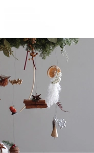 Detail view of a vintage Christmas bell hanging with cinnamon rolls and pine needles