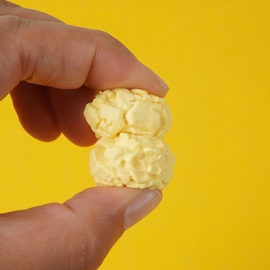 Realistic spherical PVC popcorn model prop held in hand with textured detail