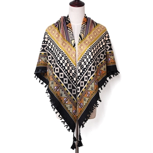 Detail of bohemian scarf with ethnic geometric patterns and black knotted tassels
