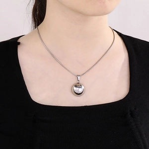 Close-up of minimalist silver hollow heart pendant on a polished snake chain necklace