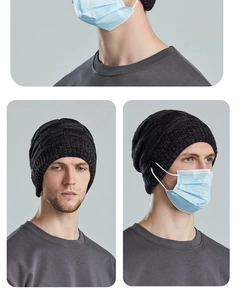 Detail of the side button on a chunky knit beanie for holding face mask straps comfortably