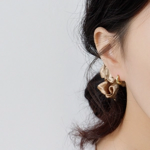 Minimalist gold hoop earrings in polished sterling silver shown on model's ear