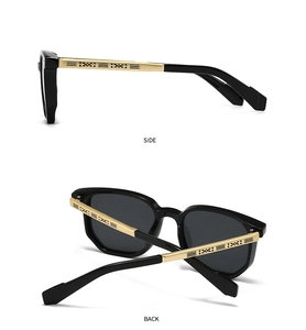 Detail view of square black pilot sunglasses with gold engraved metal temple accents
