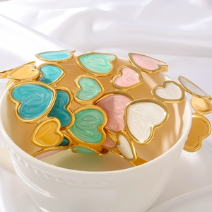 Golden titanium steel open bracelets with colorful enamel hearts on white ceramic