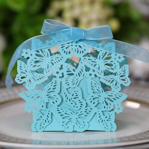 Close-up of light blue laser-cut butterfly candy box with silk ribbon and pearl paper