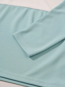Détail du tricot gaufré bleu clair et des coutures sur ce pull à manches longues homme