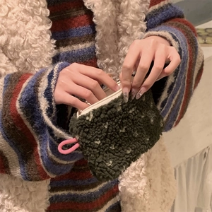 Detail of plush dark green faux shearling coin purse with pink loop and zipper