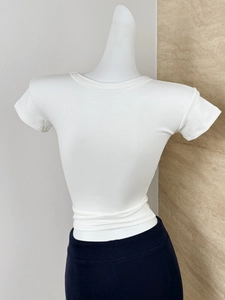 Close-up of a white modal ribbed slim-fit t-shirt showing fine knit texture on a mannequin