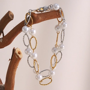 Minimalist 18K gold plated stainless steel pearl bracelet hanging on a branch