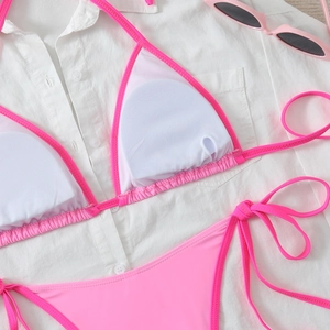 Detail of hot pink bikini set with removable white pads and crisscross side ties