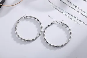 Detailed view of silver bamboo pattern hoop earrings with large circular hinge design