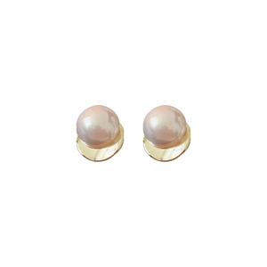 Elegant geometric golden metal stud earrings with large pink pearls on white background