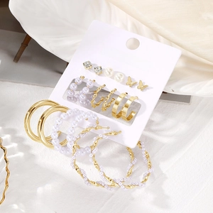 Detail view of 9-piece gold earring set with butterflies, pearls and crystals on display card