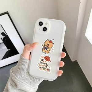 Close-up of clear phone case with cute hand-drawn cartoon cats and cherry illustrations