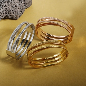Detailed view of three 18K gold-plated bracelets in silver, gold, and rose gold finishes