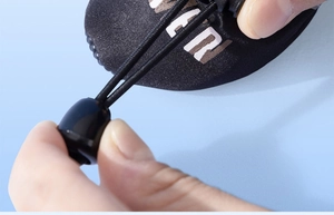 Detail of adjustable drawstring toggle and black fabric on anti-slip dog boots