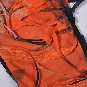 Dettaglio del tessuto a rete arancione con ombre tie-dye e design con lacci e frange