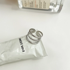 Close-up of three-layer silver stainless steel ring set on a soft minimalist background