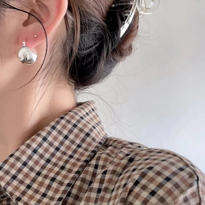 Minimalist 925 sterling silver sphere stud earrings on model wearing checkered shirt