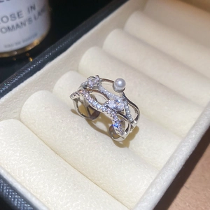 Macro shot of silver multilayer ring featuring sparkling zircons and a white pearl accent